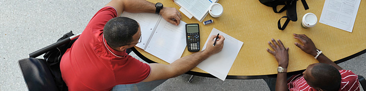 A man with a red shirt advises another man.