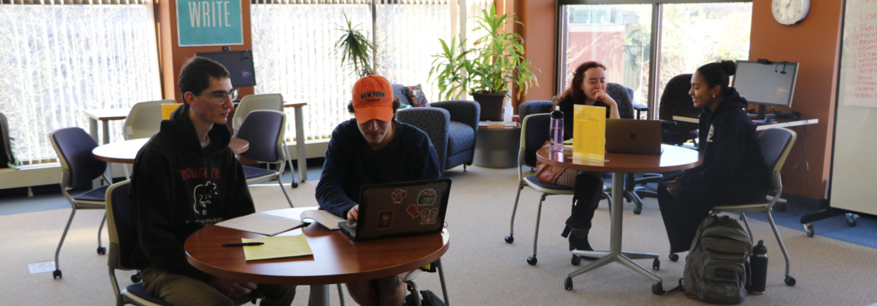 students sitting at tables on laptops