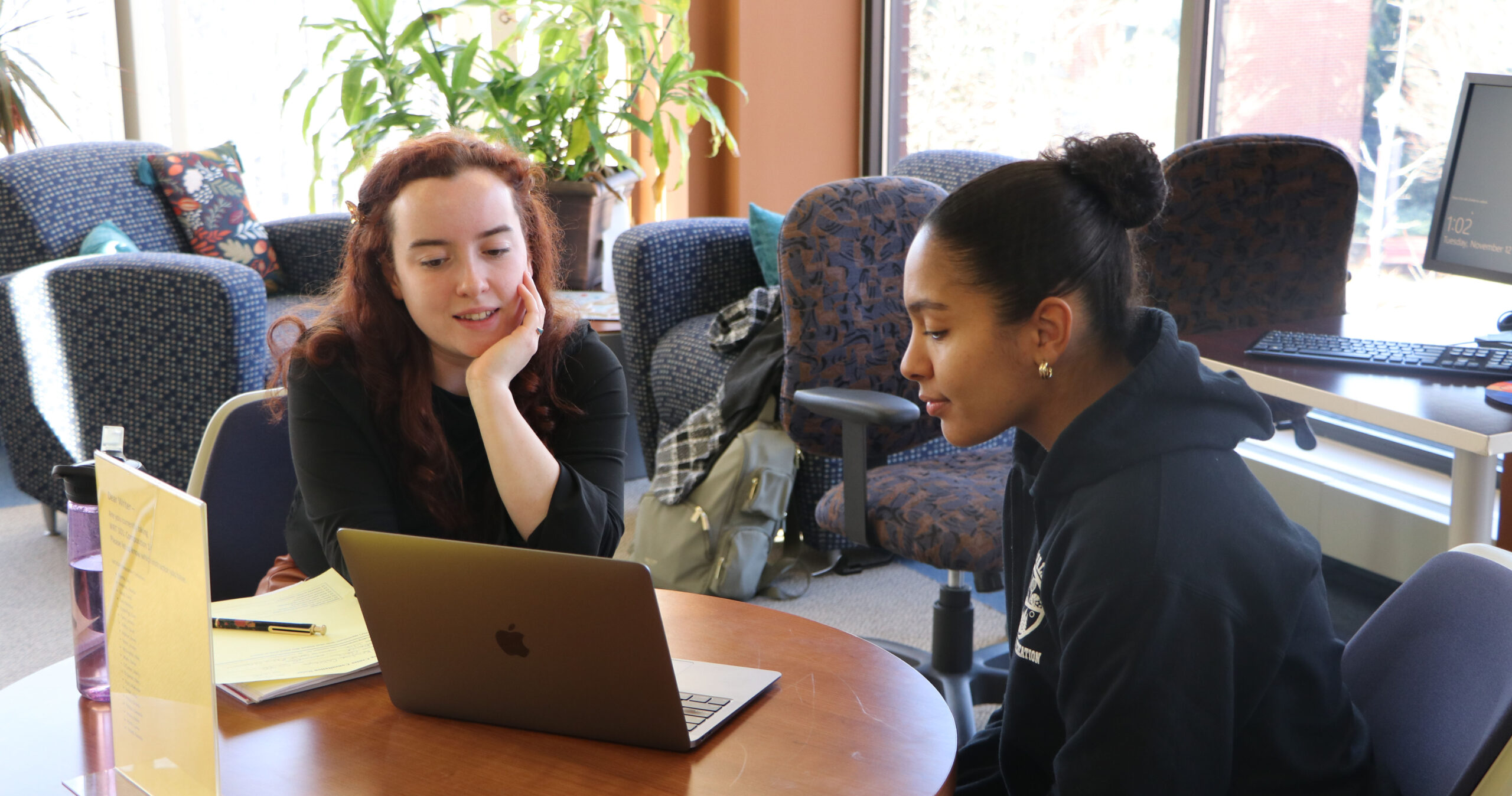Two students looking at a laptop