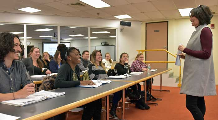 Instructor engaging with students from the education program in a classroom