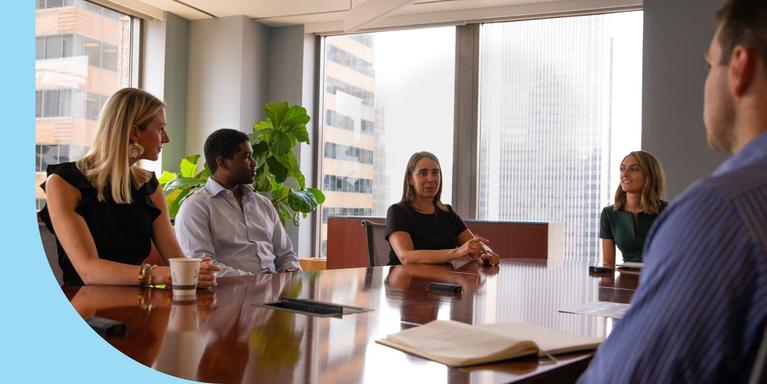 5 people sitting attentively in a business meeting