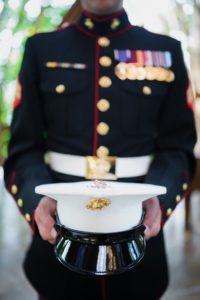 Marine standing holding a Officers hat.