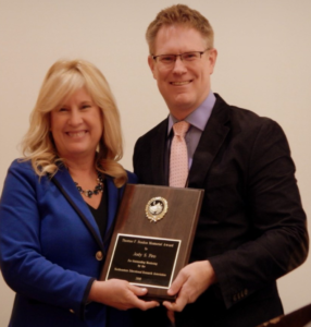 Dr. Piro hold her NERA award in 2019