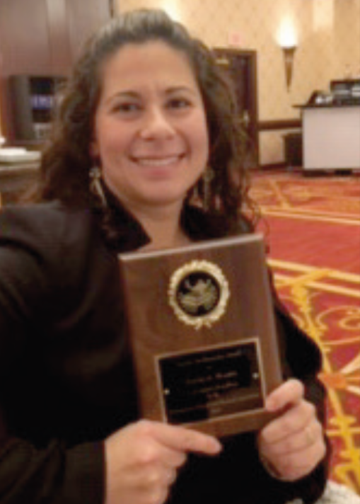 Natalie Morales holding an award plaque