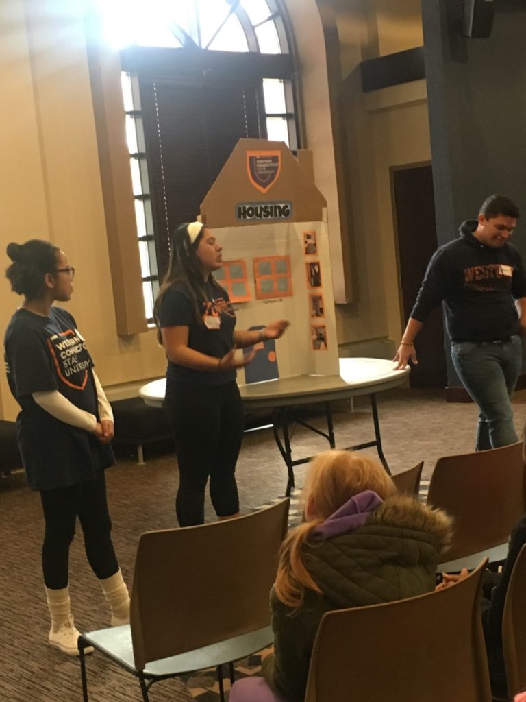 Several students standing in front of a project board, presenting at the Diversity Event at WCSU