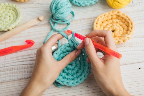 Hands making a crochet circle