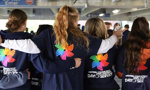 Day of Service - Students wearing the navy blue shirt with the colorful logo