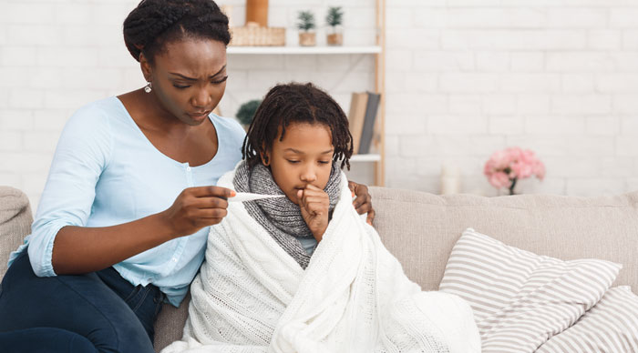 A mother taking her ill son's temperature