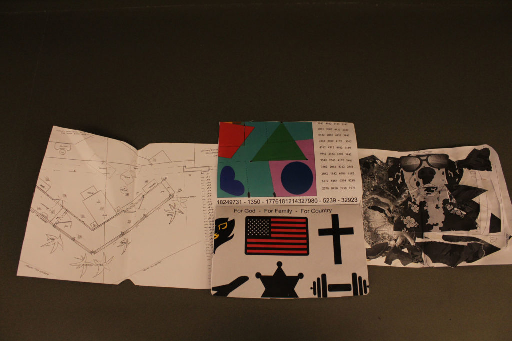 The paper on the left is the layout of a room. The top paper in the middle has numbers and colorful shapes on it. The paper below has a U.S. flag, a cross, and other symbols on it. The paper on the right has sunglasses and other miscellaneous objects on it.