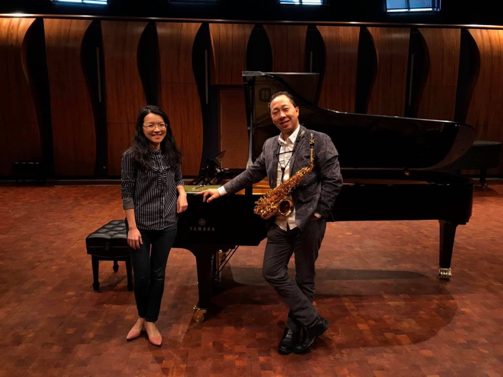 Dr. Liang-Fang Chang and Kenneth Tse pose together in front of a piano at their recital.