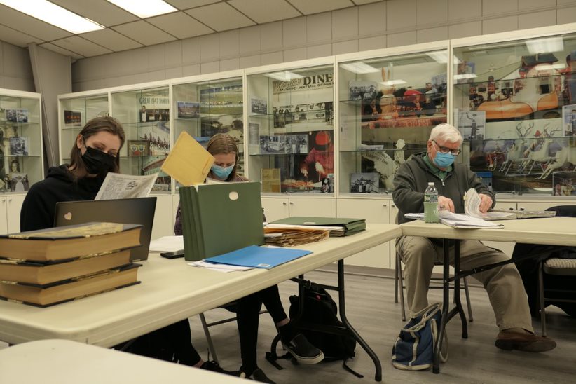 Students look through files and folders as they research Danbury's history of hatmaking.