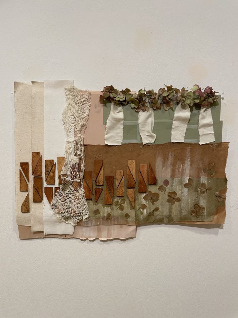 Collage made of various rectangular fabrics. Little wood blocks form rectangles toward the bottom, and clovers are at the top on a sage green piece of fabric and on the bottom on a brown piece of fabric.
