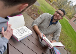 WCSU alumnus Nicolas DiDomizio signs a copy of his book for Writing major Mathew Schumer, of Newtown.