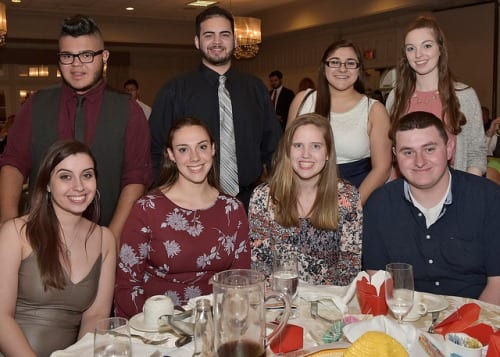Four students pose behind a table at the Student Leadership Recognition Banquet in the Amber Room