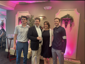 Michael Ances holding his crystal apple Teacher of the Year Award with his wife, Leigh, and sons Spencer (left) and Hunter (right.