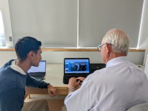 Senior Cameron Kurasz assists Neal Macmillen with PowerPoint for his forecast.