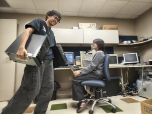Students Ismael Shaker and Chloe Wong surrounded by vintage computers currently under repair.