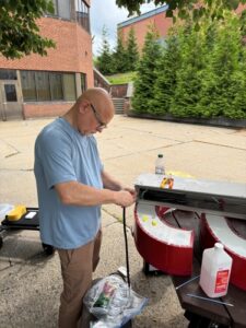 MIS Professor Dr. Emilio Collar works on refurbishing the vintage "Computers" sign.