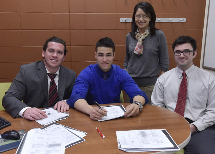 Image of Zachary Goodwin, Thomas Chin and Domenic Bartolomeo, with WCSU Assistant Professor of Finance Dr. Carol Huang 