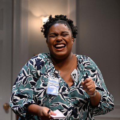 Student laughing on stage in a WCSU production