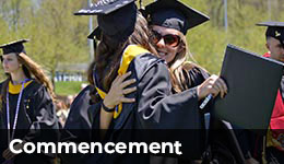 Commencement - two students hugging at their commencement ceremony